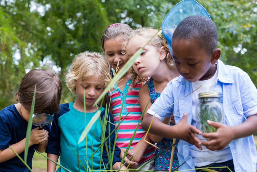 children looking through a magnifying glass